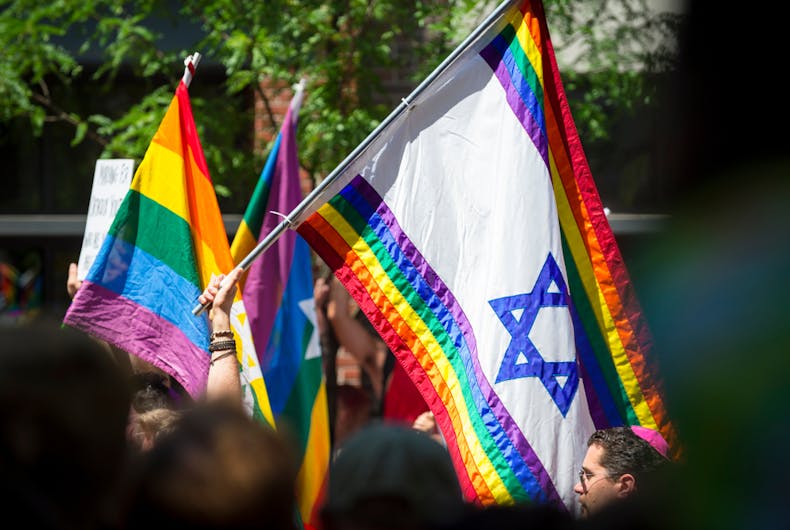 JUNE 25, 2017: Jewish participants wave Israeli Star of David rainbow flags as the Gay Pride Parade passes through Greenwich Village.