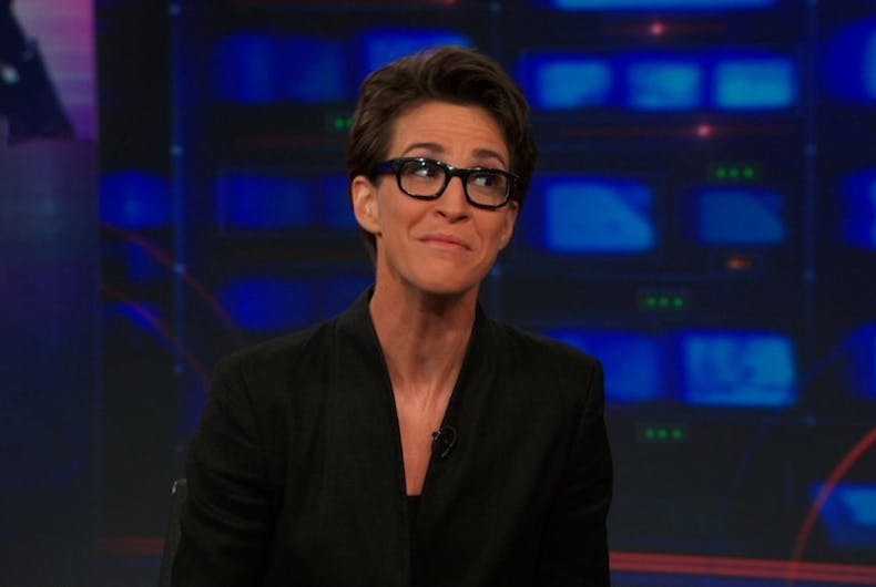 Rachel Maddow, a lesbian newscaster in horn rimmed glasses, grimaces while on 