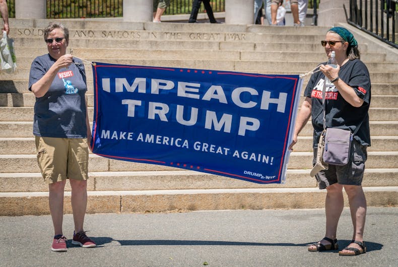 shutterstock_1425786584 June 15, 2019: Citizens protest to impeach President Donald Trump at a rally held in front of the state capital building in Boston, MA.